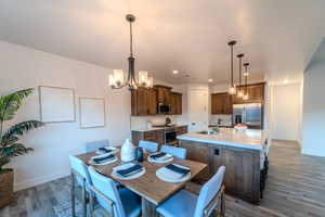 Dining room with an inviting chandelier, dark hardwood / wood-style flooring, and sink