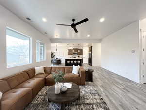 Living room with wood-type flooring and ceiling fan