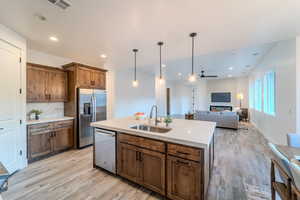 Kitchen with a center island with sink, stainless steel appliances, ceiling fan, pendant lighting, and sink