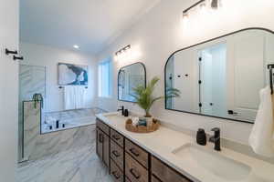 Bathroom featuring shower with separate bathtub and vanity