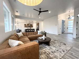 Living room featuring hardwood / wood-style flooring and ceiling fan with notable chandelier