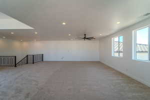 Empty room featuring light carpet and ceiling fan