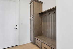Mudroom with light wood-type flooring and baseboards