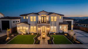 View of front of property with a balcony and a yard