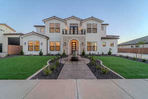 Mediterranean / spanish home featuring a front lawn and a balcony