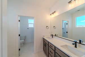 Bathroom featuring tile patterned flooring, vanity, and toilet