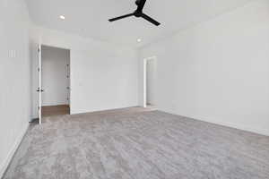 Carpeted empty room featuring a ceiling fan and recessed lighting