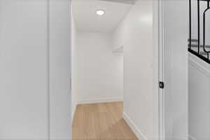 Corridor with light wood finished floors and recessed lighting