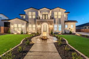 View of front of property with a front yard and a balcony