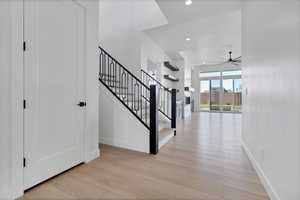 Foyer entrance featuring light wood-type flooring, stairs, a ceiling fan, and recessed lighting