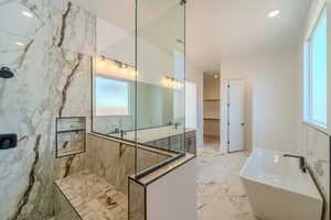 Bathroom with tile walls, plus walk in shower, and plenty of natural light