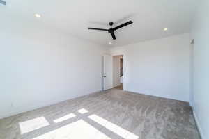 Unfurnished room with light carpet and ceiling fan