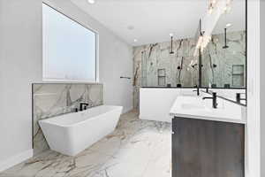 Bathroom featuring marble tiled floors, a freestanding tub, double vanity, a marble finish shower, and recessed lighting
