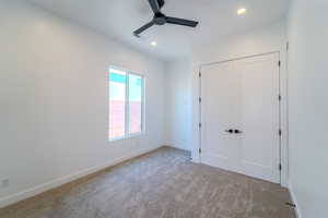 Unfurnished bedroom featuring light carpet, ceiling fan, and a closet