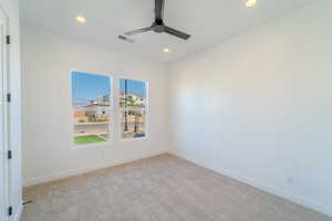 Carpeted empty room featuring ceiling fan