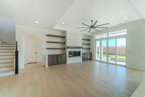 Unfurnished living room with ceiling fan and light hardwood / wood-style flooring