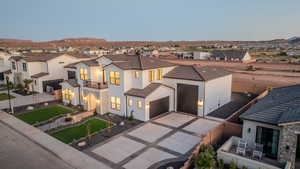 View of front of property with a mountain view, a garage, and a balcony