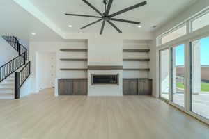 Unfurnished living room with light wood-type flooring and ceiling fan