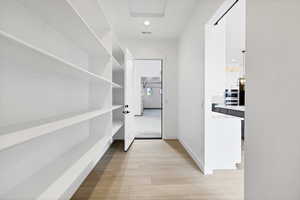 Corridor featuring light wood-style flooring and recessed lighting