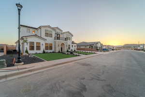 View of front of property with a balcony and a yard