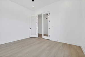 Empty room featuring light wood finished floors, a ceiling fan, and recessed lighting