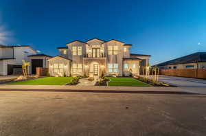 View of front of property featuring a balcony and a garage