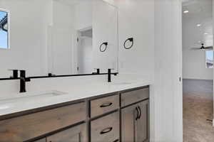 Full bathroom with double vanity, recessed lighting, and ceiling fan