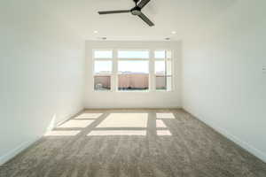 Carpeted spare room with ceiling fan