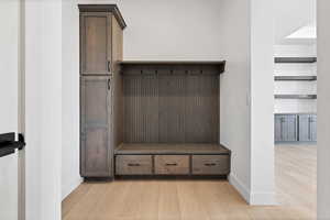 Mudroom featuring baseboards and light wood-type flooring