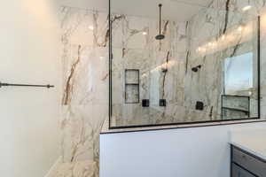 Bathroom with vanity and tiled shower