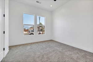 Carpeted spare room with baseboards and recessed lighting