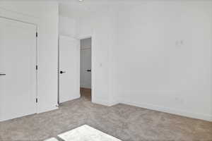 Unfurnished bedroom featuring carpet floors and baseboards