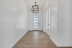Entryway with a chandelier and light wood-style floors