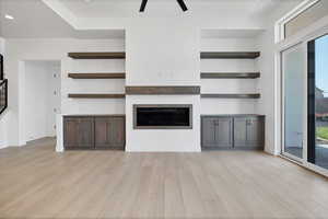 Unfurnished living room with light wood-type flooring, a fireplace, stairway, recessed lighting, and ceiling fan