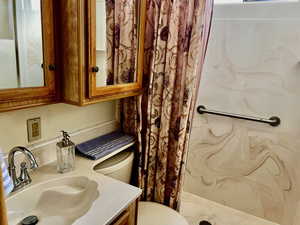 Bathroom with toilet, sink, and walk in shower