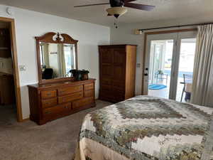 Bedroom featuring access to outside, ceiling fan, carpet, and a textured ceiling