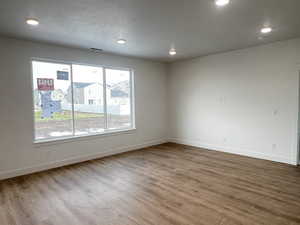 Great room with a textured ceiling and hardwood / wood-style flooring