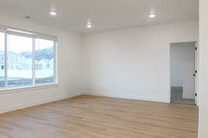 Empty room with light hardwood / wood-style floors, plenty of natural light, and a mountain view