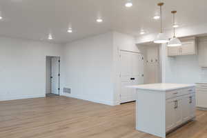 Kitchen featuring a center island, light hardwood / wood-style flooring, and decorative light fixtures