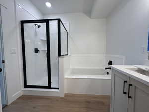 Bathroom with separate shower and tub, vanity, and hardwood / wood-style flooring