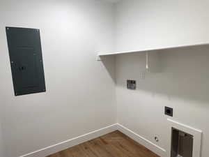 Laundry room featuring electric dryer hookup, gas dryer hookup, electric panel, hardwood / wood-style flooring, and washer hookup