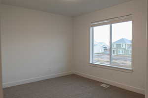 Spare room with carpet floors and a wealth of natural light