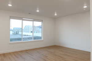 Spare room with light wood-type flooring and plenty of natural light