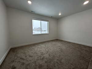 Unfurnished room with dark colored carpet