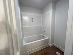 Bathroom with shower / bath combination and wood-type flooring