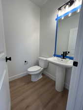 Bathroom with wood-type flooring, toilet, and sink