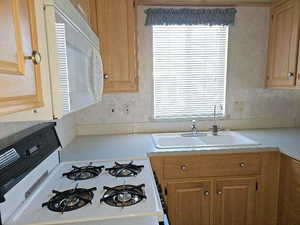 Kitchen with white appliances and sink