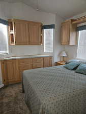 Carpeted bedroom with lofted ceiling