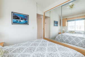 Bedroom featuring a closet, lofted ceiling, ceiling fan, and wood finished floors