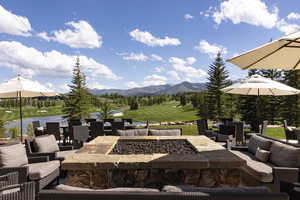 View of patio with an outdoor fire pit and a water and mountain view